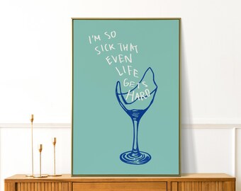 May include: A framed art print featuring a teal background with a blue illustration of a broken wine glass. The text "I'M SO SICK THAT EVEN LIFE GETS HARD" is written in white above the glass.