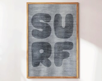 May include: A framed wall art piece with the word "SURF" in large, rounded, dark gray letters. The letters are on a textured, light gray background, and the frame is a natural wood color. The artwork is rectangular and suitable for home decor.