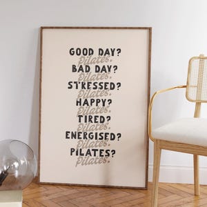 May include: A framed print with the text "GOOD DAY? Pilates. BAD DAY? Pilates. STRESSED? Pilates. HAPPY? Pilates. TIRED? Pilates. ENERGISED? Pilates. PILATES? Pilates." in black and grey lettering.