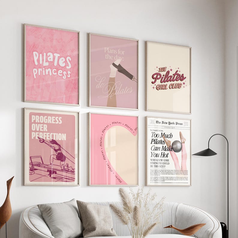 May include: A collection of framed wall art with a Pilates theme. The art features pink and beige tones with text like "Pilates Princess", "Progress Over Perfection", and "Too Much Pilates Can Make You Hot".