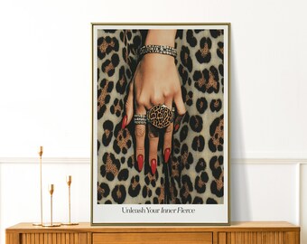 Könnte beinhalten: Gerahmter Druck mit einer Hand, die mit Ringen und einem Armband geschmückt ist, vor einem Leopardenmuster-Hintergrund. Die Nägel sind rot lackiert. Der Text "Unleash Your Inner Fierce" steht unten.