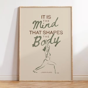 Op de afbeelding: Een ingelijste poster met de quote "IT IS THE Mind THAT SHAPES THE Body" in groene en bruine tekst. Een lijntekening van een persoon in een yogahouding staat onder de tekst. De quote wordt toegeschreven aan Joseph Pilates.