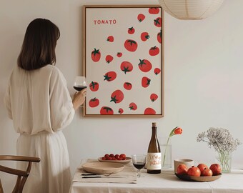 May include: A framed art print featuring a pattern of red tomatoes with green stems on a cream background. The word "TOMATO" is printed in red at the top. A woman is holding a glass of red wine near a table set with food and wine.