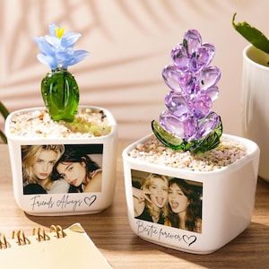 May include: Two white square ceramic planters filled with small pebbles, each featuring a custom photograph and text. The left planter has a blue glass flower and the text "Friends Always" with a heart. The right planter has a purple glass flower and the text "Bestie forever" with a heart.