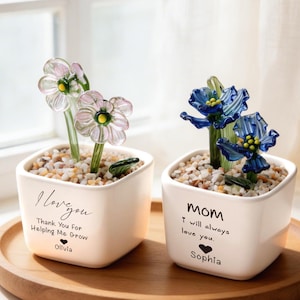 May include: A set of three ceramic mugs with a speckled, matte finish. Each mug features a different color: light blue, cream, and gray. The mugs have a simple, modern design and a comfortable handle.