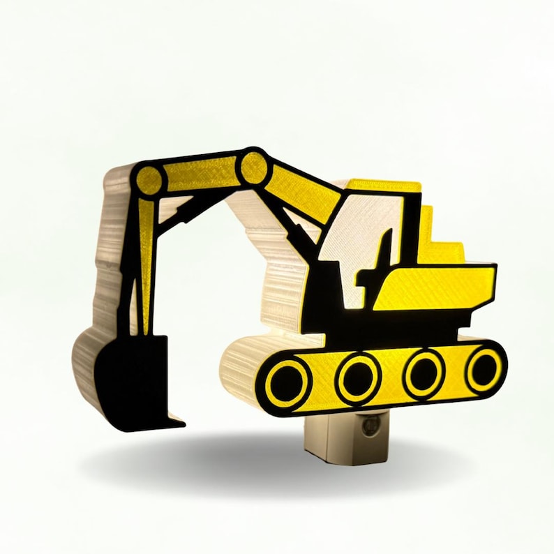 May include: A yellow and black excavator-shaped night light with a layered, textured construction. The design features a prominent mechanical arm, a bucket, and a tracked base, mounted on a standard plug-in base for wall outlet use.