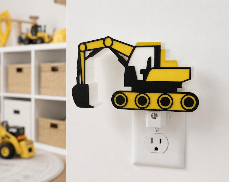 May include: A yellow and black excavator-shaped night light plugged into a standard wall socket. The construction vehicle design features a prominent mechanical arm, a cab, and tracked wheels, all rendered in a flat, layered aesthetic.