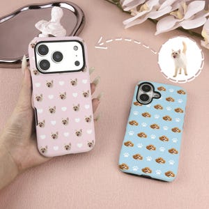 Könnte beinhalten: Zwei Handyhüllen mit Tiermotiven. Eine Hülle ist hellrosa mit einem Muster aus Hundegesichtern und Herzen. Die andere ist hellblau mit einem Muster aus Hundegesichtern und Pfotenabdrücken. Die Hüllen werden auf einer rosa Oberfläche gezeigt.