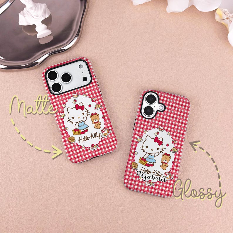 May include: Two phone cases with a red and white checkered pattern. Each case features a Hello Kitty design with a bow, dress, and teddy bear. One case is labeled "Matte" and the other "Glossy".