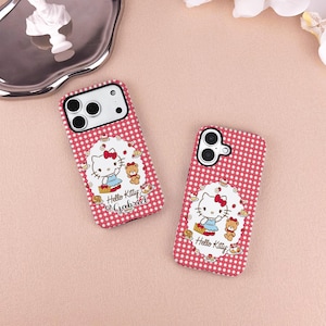 May include: Two red and white checkered phone cases featuring a Hello Kitty design. Each case has a white oval with Hello Kitty, a teddy bear, and the text "Hello Kitty Gabriel". The cases are on a pink surface.