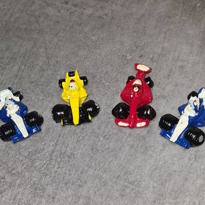Cuatro figuras  de coches de carreras