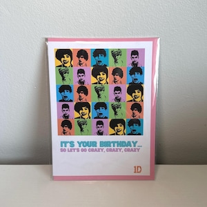 May include: A birthday card with a pink border, displaying a grid of pop art portraits in various colours. The text reads "IT'S YOUR BIRTHDAY... SO LET'S GO CRAZY, CRAZY, CRAZY" with the "1D" logo. The portraits are in a variety of bright colours.