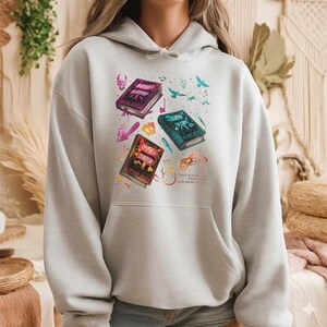 Dungeon Crawler Carl Hoodie in Sand, featuring Princess Donut and Mongo the dinosaur. Desperado Club logo with 'Princess Donut Approved' text. Retro vintage graphic of a cat and dinosaur on a premium hooded sweatshirt. Perfect gift for LitRPG fans and Matt Dinniman book lovers.