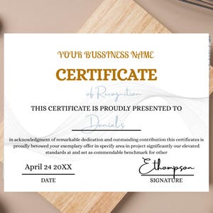 May include: A certificate of recognition with gold and grey text. The certificate reads "YOUR BUSINESS NAME CERTIFICATE of Recognition THIS CERTIFICATE IS PROUDLY PRESENTED TO Daniel's". Includes a date and signature line.