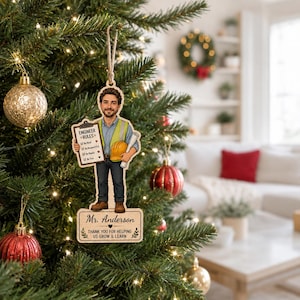 May include: A wooden Christmas tree ornament featuring a cartoon illustration of an engineer wearing a yellow safety vest, holding a clipboard labeled ENGINEER RULES and a yellow hard hat. The base is engraved with Mr. Anderson and text.