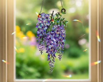 Peut inclure: Suspension de fenêtre en vitrail représentant des glycines. Les fleurs violettes et bleues pendent d'une branche avec des feuilles vertes. La suspension de fenêtre est suspendue par une chaîne argentée. L'arrière-plan est une vue floue d'un jardin.