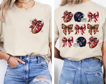 以下が含まれることがあります： 前面に赤いリボンが付いたフットボールが描かれたベージュのTシャツ。シャツの背面には、フットボール、ヘルメット、リボンのパターンが表示されています。シャツはブルージーンズと組み合わせています。デザインには「DESIGN」という文字が含まれています。