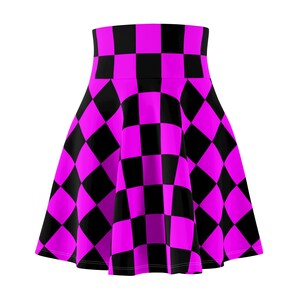 May include: A skater skirt featuring a bold checkerboard pattern in black and vibrant magenta. The skirt has a high-waisted design and a flared silhouette, perfect for a statement look. The checkered print is consistent throughout the skirt's surface.
