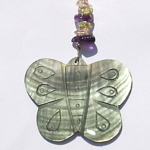 May include: A green iridescent butterfly pendant with a beaded chain featuring purple, pink, and yellow beads.