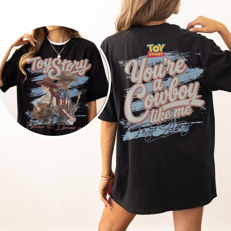 Puede incluir: Una camiseta negra con un gr&aacute;fico de Toy Story en la espalda con el texto "You're a cowboy like me" en letra grande. El dise&ntilde;o incluye un fondo de pincelada azul y el logotipo de Toy Story. Un recuadro circular muestra el gr&aacute;fico frontal.