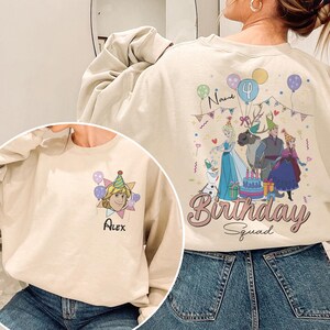 Puede incluir: Sudadera beige con un gr&aacute;fico de fiesta de cumplea&ntilde;os de dibujos animados y el texto "Birthday Squad". El dise&ntilde;o incluye personajes, globos y una tarta. La parte delantera de la sudadera tiene un gr&aacute;fico de dibujos animados y el nombre "Alex".