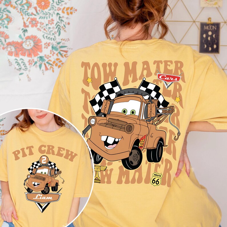 May include: Yellow t-shirt with a cartoon image of Tow Mater from the Cars film, with the text "Tow Mater" and chequered flags. The shirt also has the Route 66 logo and a smaller image of Mater on the front.