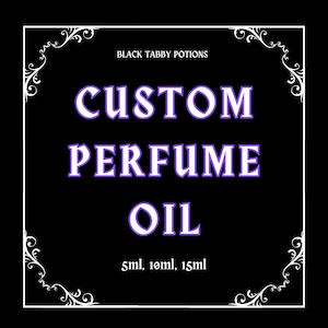 May include: Black background with white decorative border and text. The text reads "BLACK TABBY POTIONS" at the top, with "CUSTOM PERFUME OIL" in large purple letters. Below, it says "5ml, 10ml, 15ml".