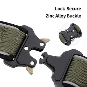 K&ouml;nnte beinhalten: Nahaufnahme einer schwarzen Zinklegierungs-Schnalle mit olivgr&uuml;nem Gurtband. Die Schnalle ist f&uuml;r sicheres Verriegeln konzipiert. Der Text auf dem Bild lautet "Lock-Secure Zinc Alloy Buckle". Die Schnalle ist wahrscheinlich f&uuml;r ein Hundehalsband oder ein &auml;hnliches Produkt.