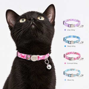 May include: A black cat wearing a pink floral cat collar with a silver bell and a round metal tag engraved with CUSTOM 123 456 7890. Four additional collar options are displayed on the right: Lilac Ditsy, Navy Ditsy, Crimson Ditsy, and Blue Lily.