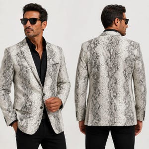 May include: A blazer featuring a grey and white snakeskin pattern, a notched lapel, two front buttons, and a chest pocket. The garment is worn over a black button-down shirt with black trousers and dark sunglasses, shown from front and back views.