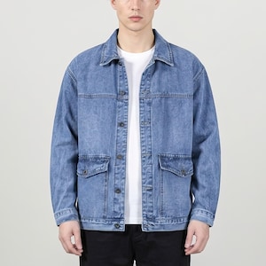 Puede incluir: Chaqueta vaquera azul claro con cuello clásico, cierre de botones y dos bolsillos delanteros. La chaqueta se lleva sobre una camiseta blanca. Las mangas son largas y la mezclilla tiene un aspecto ligeramente descolorido.