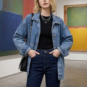 Könnte beinhalten: Hellblaue Jeansjacke mit klassischem Kragen und Knopfleiste. Die Jacke wird mit dunkelblauen Jeans und einem schwarzen Oberteil kombiniert. Eine schwarze Umhängetasche mit Kettenriemen vervollständigt den Look. Geeignet für Freizeitkleidung.