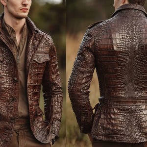 Könnte beinhalten: Braune Lederjacke mit Krokodilhautstruktur. Die Jacke hat eine Knopfleiste, zwei Brusttaschen und einen Kragen. Die Ärmel sind lang und die Jacke hat eine taillierte Passform. Die Rückansicht zeigt einen Gürtel.