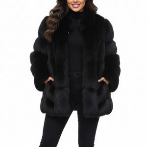 Puede incluir: Un lujoso abrigo de piel negro con un diseño clásico. El abrigo tiene cuello, mangas largas y bolsillos. La persona de la imagen lleva un cuello alto negro y pantalones negros.
