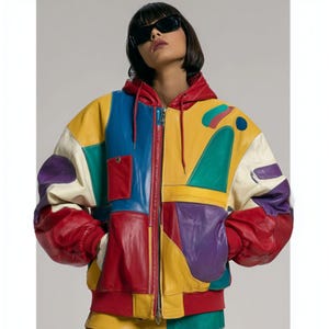 May include: A striking, colour-blocked leather jacket with a red hood and cuffs. The jacket features a patchwork design in yellow, blue, green, purple, and white. It has a front zip and a small pocket on the chest.