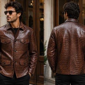 May include: A brown leather jacket with a crocodile skin effect. The jacket features a collared neckline, two chest pockets, and two lower pockets. It is buttoned and worn with black trousers. The image shows the front and back of the jacket.