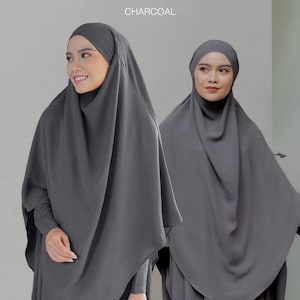 Könnte beinhalten: Zwei Frauen tragen dunkelgraue Hijabs. Die Hijabs sind über ihre Köpfe und Schultern drapiert, mit langen Ärmeln. Das Wort "CHARCOAL" ist oben im Bild aufgedruckt. Der Stoff scheint eine subtile Textur zu haben.