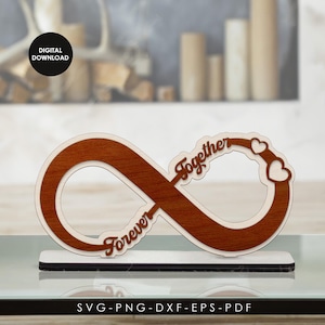 Pode incluir: Símbolo de infinito de madeira com as palavras "Forever" e "Together". O símbolo de infinito é castanho com uma borda branca e assenta numa base branca. Dois corações estão ligados à palavra "Together". A imagem também inclui o texto "DIGITAL DOWNLOAD" e "SVG-PNG-DXF-EPS-PDF".