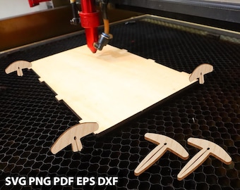 May include: A laser cutter working on a light-colored wooden project. The machine's red nozzle is positioned above the wood, with several small, T-shaped wooden pieces nearby. The text "SVG PNG PDF EPS DXF" is visible at the bottom of the image.