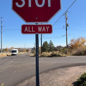 Peut inclure: Un panneau STOP octogonal rouge avec texte blanc et un panneau rectangulaire ALL WAY en dessous. Les panneaux sont mont&eacute;s sur un poteau m&eacute;tallique, avec une route et un ciel bleu en arri&egrave;re-plan.