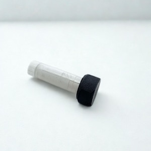 Peut inclure: Une bouteille cylindrique transparente avec un bouchon blanc et un applicateur &eacute;ponge noir et rectangulaire. La bouteille contient un liquide gris clair. L'applicateur est fix&eacute; &agrave; l'extr&eacute;mit&eacute; de la bouteille. L'objet est sur fond blanc.