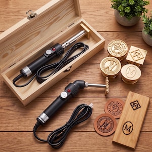May include: Two black electric branding irons with silver heating elements and power cords, one stored in a light wood box. Includes four circular and square brass stamp heads with various designs and three circular leather pieces with branded marks.