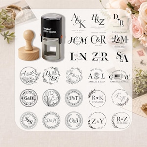 Peut inclure: Un tampon auto-encreur Trodat Printy 46050 noir et gris et un tampon avec manche en bois. L'image présente une collection de vingt-quatre motifs de monogrammes à l'encre noire avec diverses initiales, couronnes florales, dates et noms.