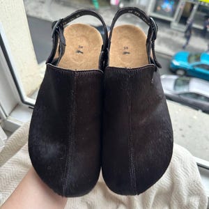 Dark brown suede anatomical clogs with round toe and adjustable buckle strap, handmade footwear