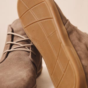 Close-up of gray suede barefoot boots with flexible sole