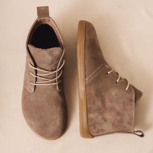 Pair of gray suede barefoot boots on neutral background