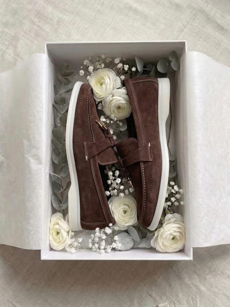 Handmade brown suede loafers in gift box with premium packaging and floral decoration.