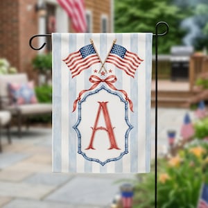 May include: A rectangular garden flag featuring a light blue and white vertical striped background. Centered is a red letter A inside a blue bamboo-style frame, topped with a red ribbon bow and two crossed American flags with gold finials.