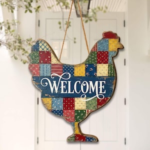 May include: Wooden chicken-shaped welcome sign with a patchwork design. The sign features a blue base with the word "WELCOME" in white script. The chicken's body is made of colorful fabric squares, and it hangs from a jute rope.