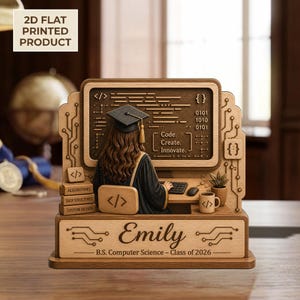 May include: A wooden desk ornament featuring a computer science graduate in a cap and gown, seated at a computer. The ornament includes the name "Emily", the text "B.S. Computer Science - Class of 2026", and coding symbols.